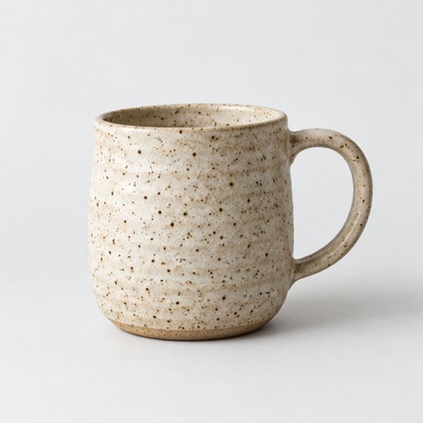 A hand-thrown mug in a speckled oat glaze